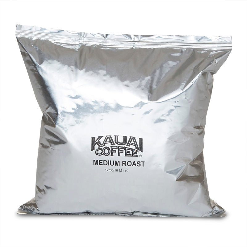 Silver coffee bag labeled "Kauai Coffee Medium Roast" on a white background.